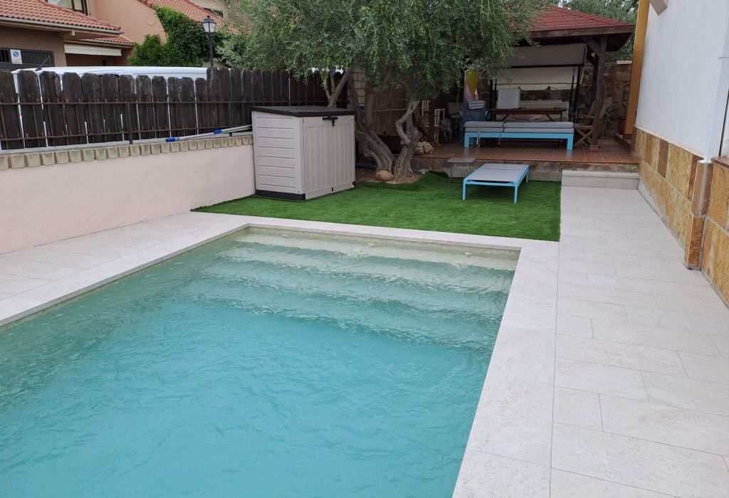 Minimalist swimming pool design with modern architecture and glass fencing.